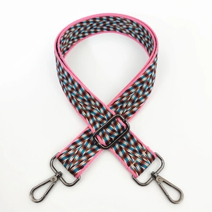 Detail of bohemian pink woven shoulder strap with geometric patterns and grey metal hooks
