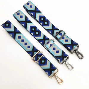Detailed close-up of ethnic geometric bag straps with gold silver and black metal hardware