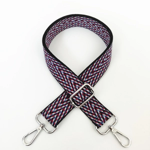 Detail of colorful geometric wave pattern woven nylon shoulder strap with silver hooks