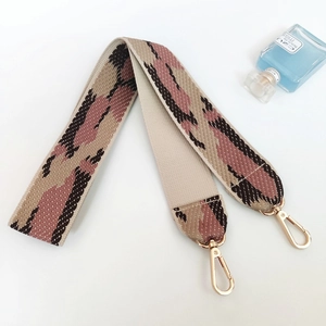 Close-up of wide geometric python print shoulder strap with polished gold lobster clasps