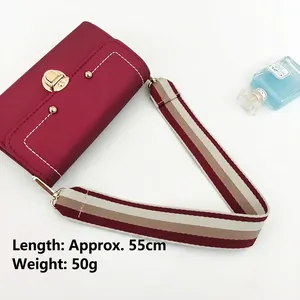 Burgundy leather crossbody bag with red and white striped wide strap and gold metal clasp