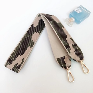 Detail of wide camo jacquard shoulder strap with high-quality gold lobster clasps