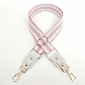 Détail de la bandoulière tressée rayée rose et blanc avec boucle et crochet dorés