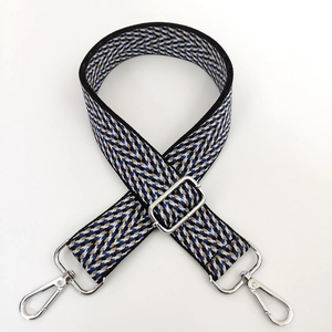Close-up of woven herringbone bag strap with silver metal swivel hooks and adjuster