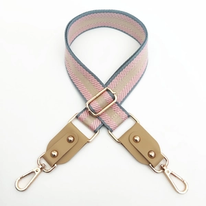Détail de la bandoulière tissée à rayures roses et bleues avec attaches en cuir