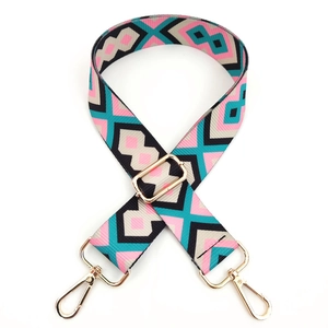 Close-up of geometric patterned colorful woven bag strap with golden metal swivel hooks