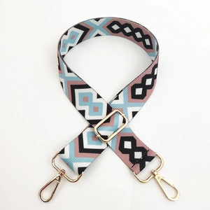 Detail of adjustable geometric diamond pattern bag strap with gold metal lobster clasps