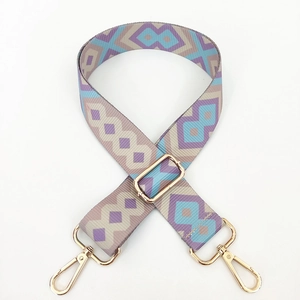 Close-up of geometric pattern shoulder strap with gold metal buckles for handbags