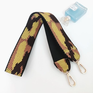 Detailed close-up of colorful camouflage woven shoulder strap with gold lobster clasps