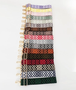 Détail des motifs tricotés géométriques sur des bandoulières colorées de 5 cm avec crochets
