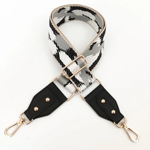 Détail de la bandoulière large tissée réglable avec motif pied-de-poule et rivets dorés