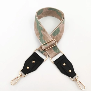 Détail de la bandoulière camouflage réglable avec clous dorés et fermoirs mousquetons