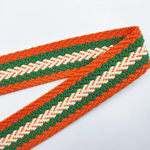 Détail d'une bandoulière tissée de 3,8 cm avec des motifs géométriques orange et vert