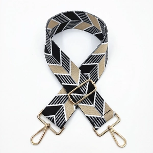 Close-up of geometric wave pattern jacquard bag strap with gold metal lobster clasps