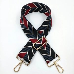 Close-up of wide adjustable shoulder strap with red and blue V-pattern and gold hooks