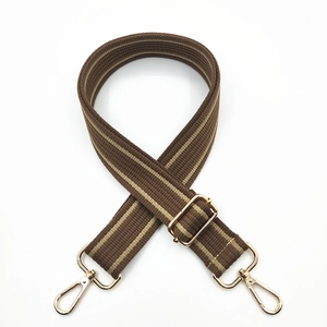 Detail of adjustable brown striped cotton bag strap with gold metal buckles