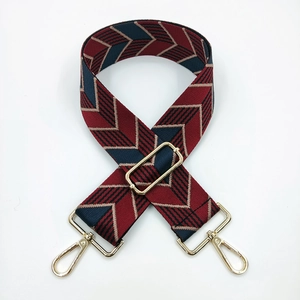 Detail of adjustable jacquard bag strap with navy and burgundy chevron pattern and gold clips