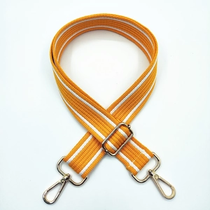 Detail of wide orange woven bag strap with white stripes and gold metal lobster clips