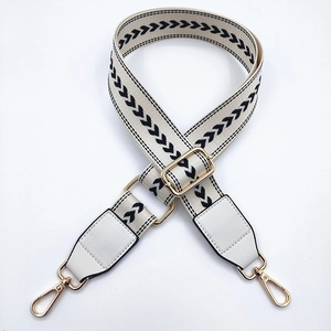 Detail of adjustable nylon bag strap with black chevron pattern and gold lobster claws