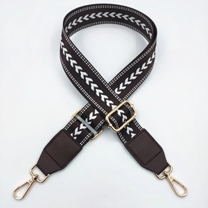 Detail showing embroidered chevron nylon shoulder strap with brown leather and gold hardware