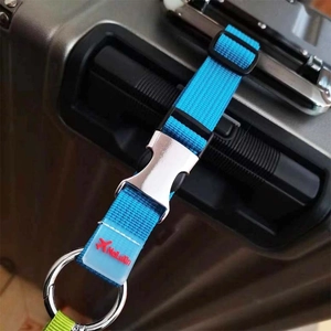 Détail de la sangle de bagage bleue en nylon avec boucle et anneau sur une poignée de valise