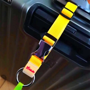 Détail de la sangle à bagages jaune en nylon avec boucle métallique sur la poignée