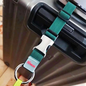 Détail d'une sangle de bagage en nylon vert foncé avec boucle en métal argenté