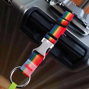 Vue détaillée d'une sangle de bagage arc-en-ciel avec boucle en métal sur une valise