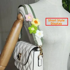 Detail of crochet floral strap on white quilted crossbody bag with golden hardware