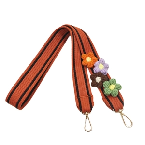 Thick woven bag strap with colorful crochet flower charms and golden metal lobster clasps