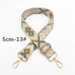 Detailed close-up of 5cm wide ethnic style jacquard woven bag strap with golden metal clips