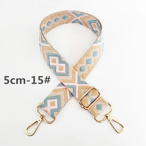 Detail showing a 5cm wide bohemian woven purse strap with gold metal buckles and lobster clips