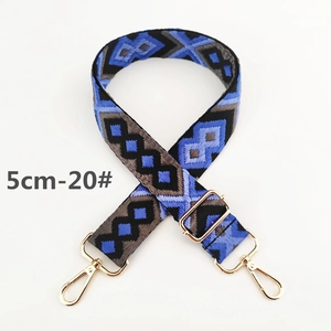 Close-up of 5cm wide jacquard woven strap with blue geometric patterns and gold metal hooks