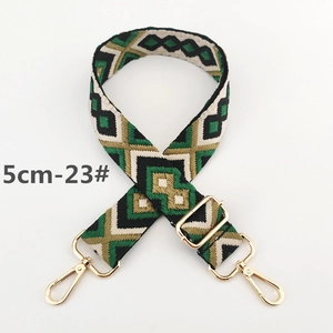 Detail of 5cm wide ethnic geometric woven bag strap with golden metal hardware hooks