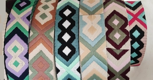 Detail of colorful ethnic embroidery patterns on adjustable canvas handbag straps