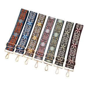 Detail of seven bohemian woven bag straps with colorful ethnic patterns and gold hardware