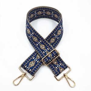 Detail of blue folk embroidered adjustable shoulder strap with gold metal lobster clasps