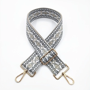 Detail of adjustable geometric woven shoulder strap with golden metal swivel hooks