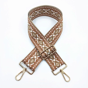 Detail of adjustable geometric ethnic style woven bag strap with gold metal buckles