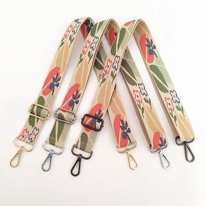 Detail of floral embroidered canvas straps with gold, silver, and gunmetal hooks