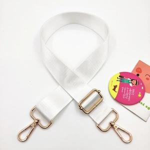 Detail of white nylon wide shoulder strap with adjustable golden metal buckle and lobster clasp
