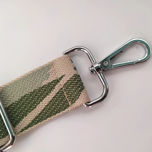 Floral embroidered canvas bag strap with green botanical patterns and silver metal hooks
