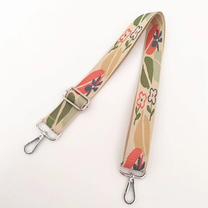 Detail view of ethnic jacquard embroidered bag strap with silver metal lobster clasps
