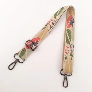 Close-up of vintage floral embroidery canvas strap with black metal swivel hooks