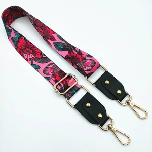 Detail of adjustable floral shoulder strap with pink base, gold rivets and metal hooks