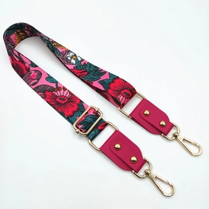Detail of adjustable rose red floral bag strap with gold metal hardware and rivets