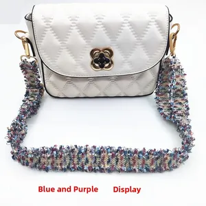 Detailansicht der weißen Stepptasche mit Kleeblatt-Schloss und blau-violettem Gurt