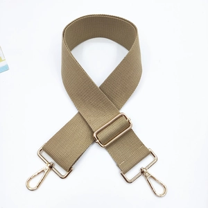 Detailed view of khaki woven bag strap with adjustable gold buckles and lobster clasps