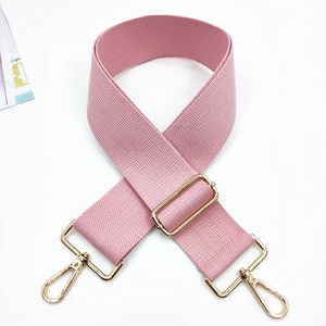 Detailed view of pink wide woven strap with adjustable golden hardware and lobster clasps