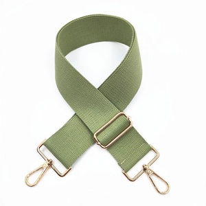 Macro shot of adjustable olive green woven shoulder strap with light gold metal lobster clasps